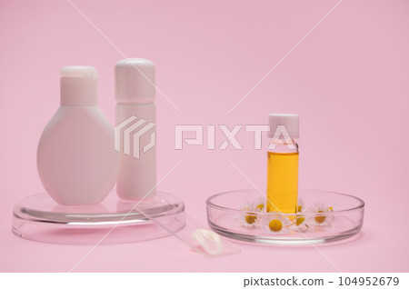 Mockup white bottles and transparent glass vial with essential oil with organic cosmetic products, on pink background 104952679