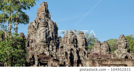 Image of the famous Bayon Temple in Cambodia on a sunny warm day, known for its architecture. Image of the famous Bayon Temple in Cambodia on a sunny warm day, known for its architecture. 104952831