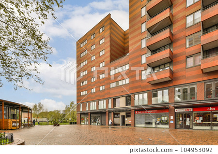 a bricked building in the middle of an urban area with buildings on either side and people walking around it a bricked building in the middle of an urban area with buildings on either side and people walking around it 104953092