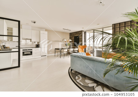 a living room with white walls and wood flooring in the center of the room is an open kitchen area 104953105