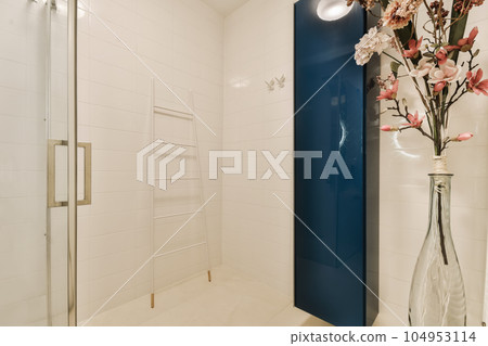 a vase with flowers in it and a blue shower stall behind the glass door that leads to a walk - in shower a vase with flowers in it and a blue shower stall behind the glass door that leads to a walk - in shower 104953114