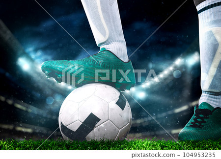 Close up of a soccer striker ready to kicks the ball at the stadium Close up of a soccer striker ready to kicks the ball at the stadium 104953235