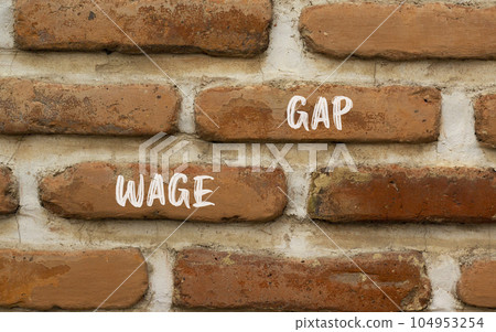 Wage gap symbol. Concept words Wage gap on beautiful brown brick wall on a beautiful brown brick wall background. Business, support and wage gap concept. Copy space. 104953254
