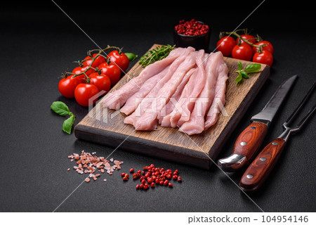 Raw chicken or turkey fillet cut into strips with spices and herbs Raw chicken or turkey fillet cut into strips with spices and herbs 104954146