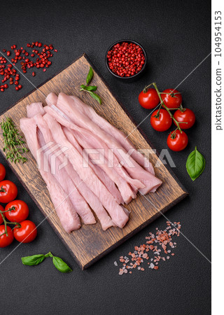 Raw chicken or turkey fillet cut into strips with spices and herbs Raw chicken or turkey fillet cut into strips with spices and herbs 104954153