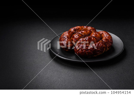 Delicious grilled sausage in the form of a ring with salt, spices and herbs Delicious grilled sausage in the form of a ring with salt, spices and herbs 104954154