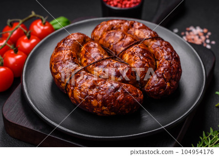Delicious grilled sausage in the form of a ring with salt, spices and herbs Delicious grilled sausage in the form of a ring with salt, spices and herbs 104954176