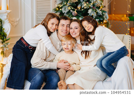 Beautiful happy large family on the couch by the Christmas tree. Beautiful happy large family on the couch by the Christmas tree. 104954531