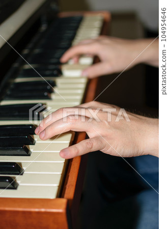 Close up view of Caucasian hands playing electric piano in bedroom 104954646