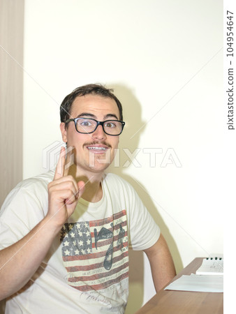 Young Man with Nerd-Style Glasses having idea pointing his finger up Young Man with Nerd-Style Glasses having idea pointing his finger up 104954647