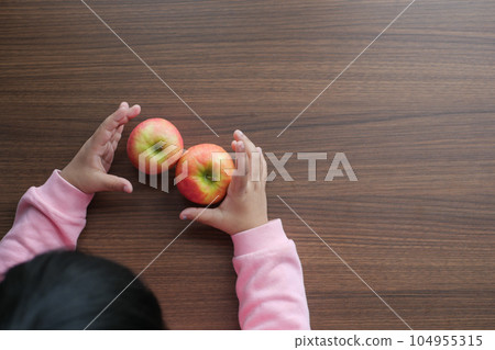 child hand hold apples on wooden table  104955315