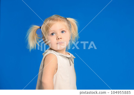 Cute little girl posing on light blue background 104955885