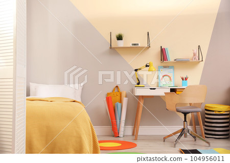 Stylish child room interior with comfortable bed and desk 104956011