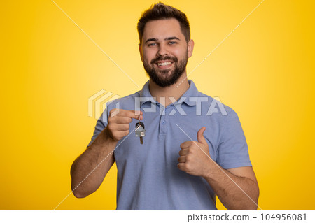 Happy young man real estate agent showing keys of new home house apartment, buying renting property 104956081