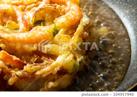 剩下的油炸食品翻拍圖像。用高湯煮炸天婦羅並裹上雞蛋的烹飪場景。 104957940