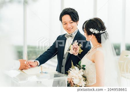 Bride and groom signing a marriage certificate / marriage vow at a wedding ceremony 104958661