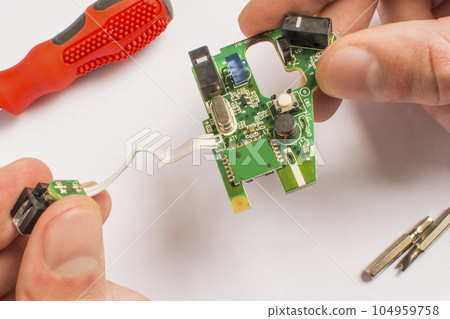 board in hand on a white background with a screwdriver board in hand on a white background with a screwdriver 104959758