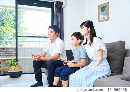 Parents and children sitting on the sofa and enjoying the game 104960498