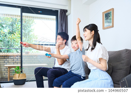 Parents and children sitting on the sofa and enjoying the game 104960507