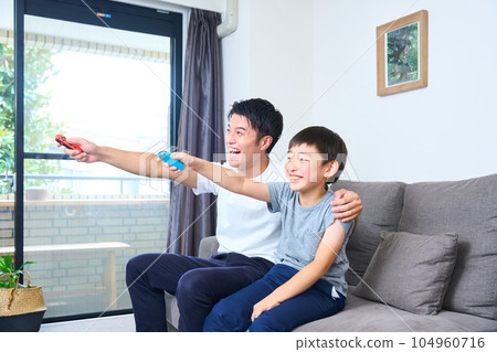 家長和孩子坐在沙發上享受遊戲 104960716