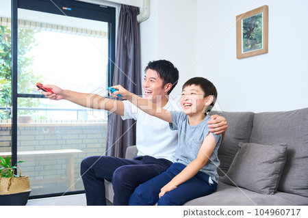 家長和孩子坐在沙發上享受遊戲 104960717