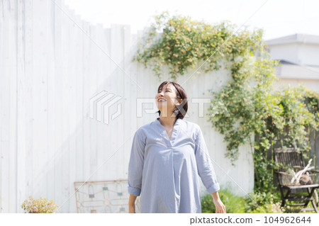 A woman in her thirties walking in the garden A woman in her thirties walking in the garden 104962644