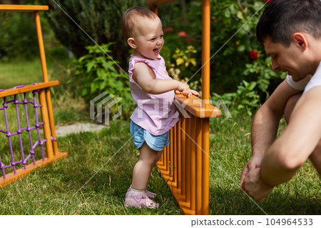 Dad with little daughter collects home sports complex outdoor. Dad with little daughter collects home sports complex outdoor. 104964533