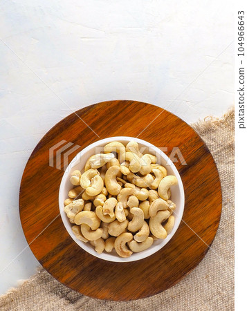 Cashew nuts in plate on wooden stand. top view with copy space. Preparation for online store or Cashew nuts in plate on wooden stand. top view with copy space. Preparation for online store or 104966643