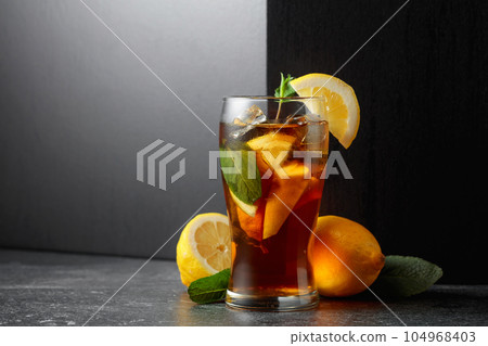 Iced tea or a summer refreshing drink with ice, mint, and lemon. 104968403