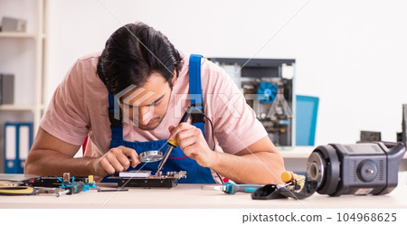 Young male contractor repairing computer Young male contractor repairing computer 104968625