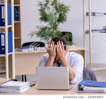 Young male bookkeeper working in the office Young male bookkeeper working in the office 104968663