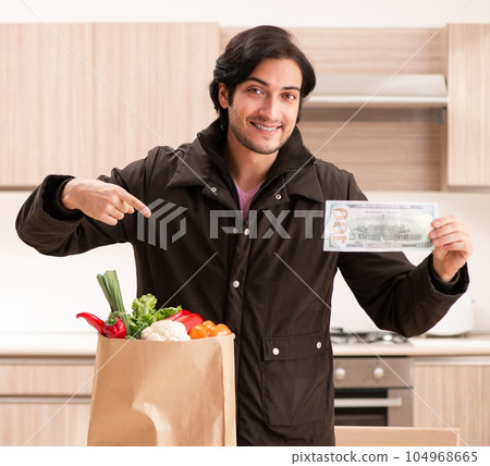Young handsome man with vegetables in the kitchen Young handsome man with vegetables in the kitchen 104968665