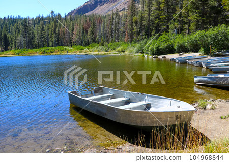 Moored small boats on the shore of a lake in the USA. Moored small boats on the shore of a lake in the USA. 104968844