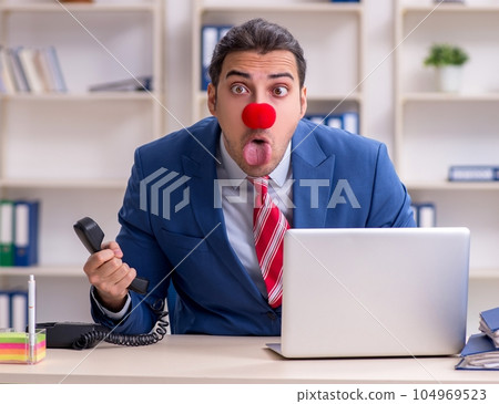 Funny employee clown working in the office Funny employee clown working in the office 104969523