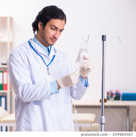 Young male doctor in blood transfusion concept 104969565
