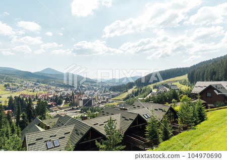 A review view of the resort city in the Carpathian mountains. Roofs of houses and mountains look very atmospheric A review view of the resort city in the Carpathian mountains. Roofs of houses and mountains look very atmospheric 104970690