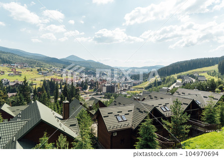 A review view of the resort city in the Carpathian mountains. Roofs of houses and mountains look very atmospheric 104970694