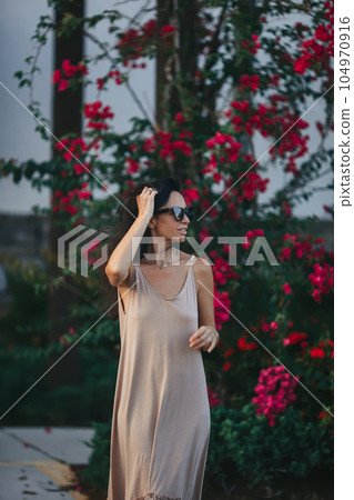 Happy young woman outdoor in the park walking at summer day Happy young woman outdoor in the park walking at summer day 104970916