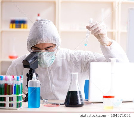 Young handsome chemist working in the lab Young handsome chemist working in the lab 104971091