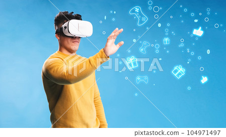 Gamer looking through VR headset in studio Gamer looking through VR headset in studio 104971497