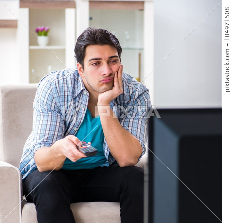 Man watching tv at home Man watching tv at home 104971508
