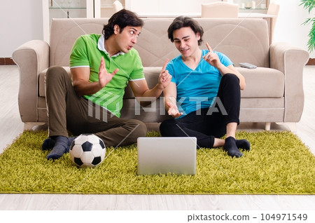 Friends watching football at home Friends watching football at home 104971549