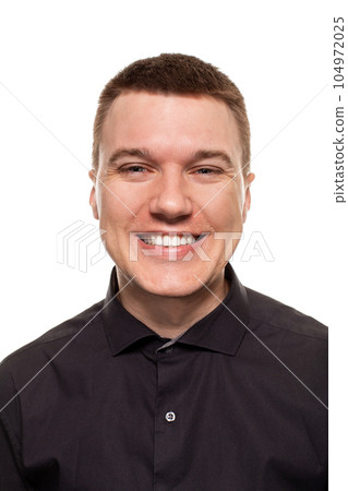 Handsome young man in a black shirt is making faces, while standing isolated on a white background 104972025
