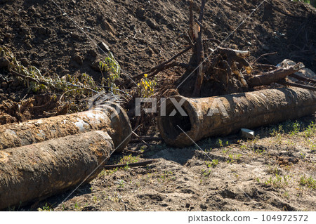 Replacement of the city water supply, old rusty pipes among the heaps of earth 104972572