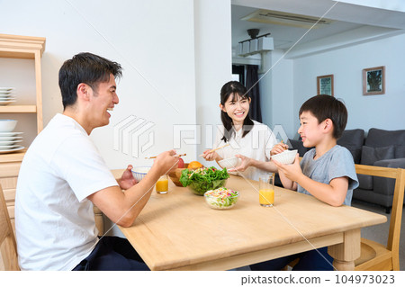 Family eating in the living dining room 104973023