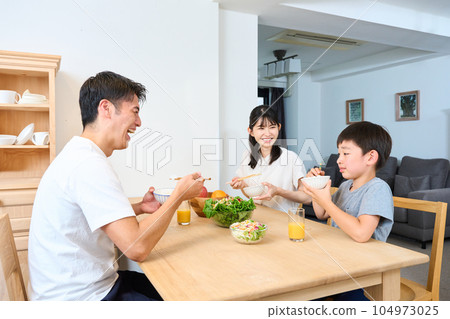 Family eating in the living dining room 104973025