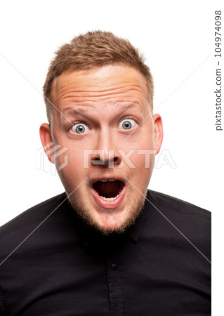 Vertical shot of stupefied stunned shocked young male keeps mouth widely opened, being surprised and very emotional, expresses great surprisment. 104974098