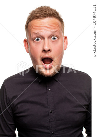 Vertical shot of stupefied stunned shocked young male keeps mouth widely opened, being surprised and very emotional, expresses great surprisment. Vertical shot of stupefied stunned shocked young male keeps mouth widely opened, being surprised and very emotional, expresses great surprisment. 104974111