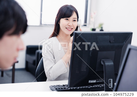 Female employee answering the phone in the office 104975229