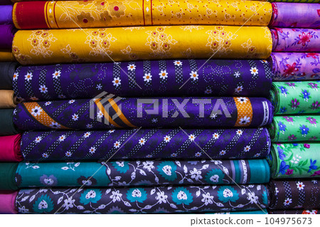 Artistic variety shade tone textile printed colors Fabrics stacked on retail Shop Shelves for sale     104975673